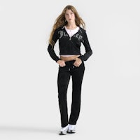 a woman wearing a black tracksuit and white sneakers