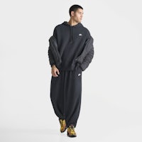 the man is wearing a black hoodie and jogging pants