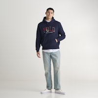 a man wearing a navy hoodie and jeans