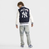 the back of a man wearing a new york yankees varsity jacket