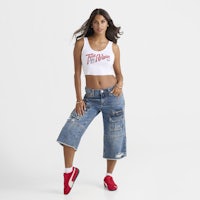 a woman wearing a crop top and denim shorts