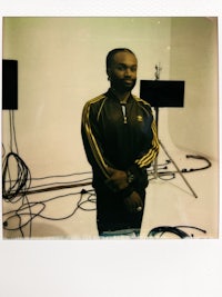 a man is standing in front of a polaroid camera