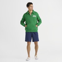 a man wearing a green sweatshirt and shorts