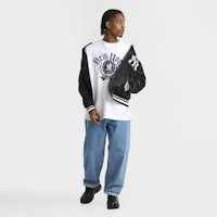 a man wearing a nba t - shirt and jeans